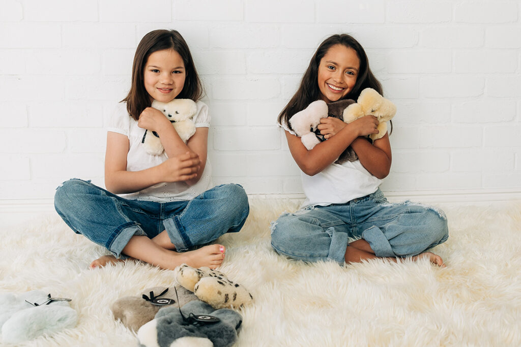 benefits of teddy bear, girls hugging a flat teddy bear